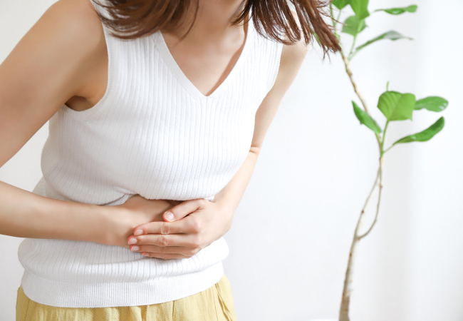 お腹を押さえる女性